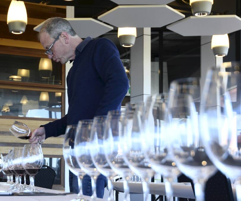 All lined up: Andrew Koerner of Blue Pyrenees inspects a red wine for depth of colour during the judging of the Ballarat Wine Show. Picture: Lachlan Bence.
