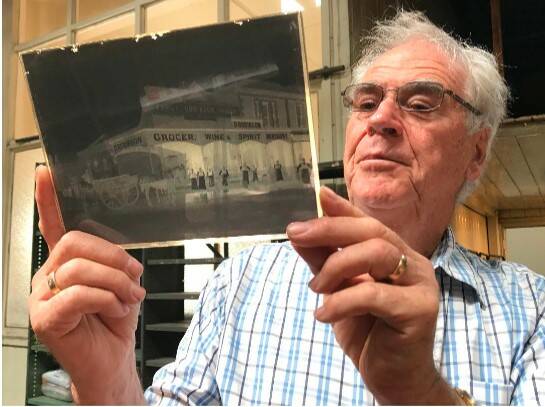 Seeking imageS: Curator Kevin Williams holds a glass plate image of early Ballarat.