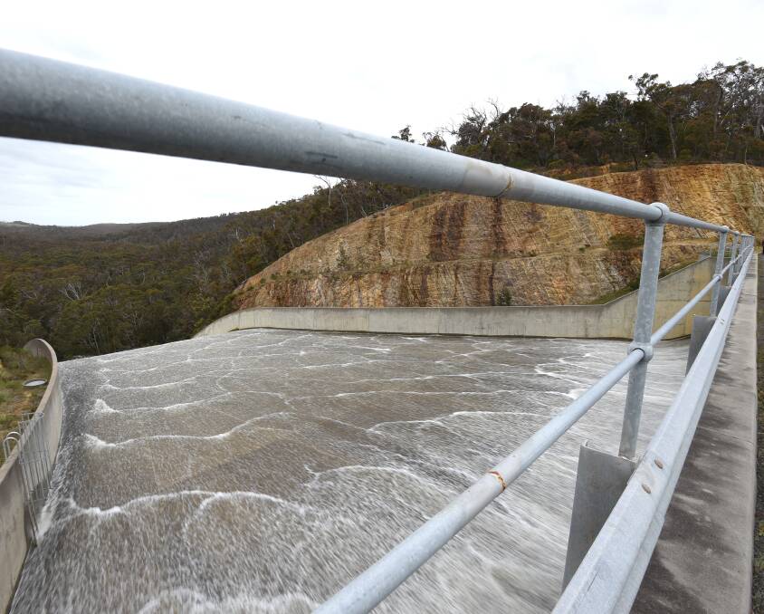 View from the bridge: a steady flow of water enters the top of the spillway. The water forms a mesmeric pattern as it begins to gather speed and head over the curve. Picture: Lachlan Bence.