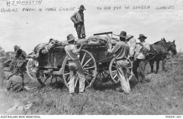 A terrible job: Loading the uncovered bodies for reburial. Picture: Australian War Memorial.