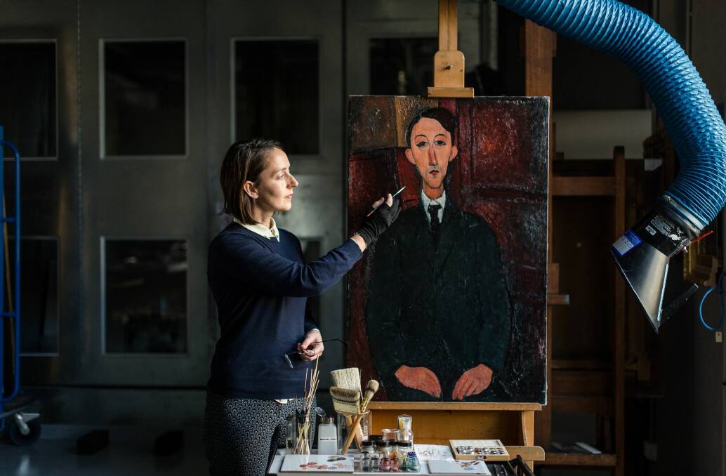 Returned to life: NGV Conservator of Paintings Raye Collins with Amedeo Modigliani’s Portrait of the painter Manuel Humbert. Photo: Eugene Hyland