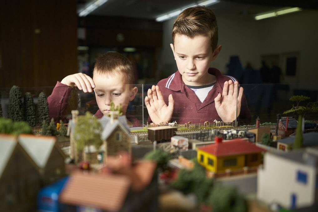 Evan Powell, 8, and Tobias Powell, 7 look at the exhibition preparations. Picture: Luka Kauzlaric
