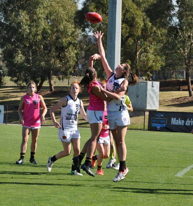 HIT-OUT: Rebels ruckman Rene Caris soars above her Bushies opponent to win the tap, helping the Rebels to a six-point victory. Pictures: Stephen Hicks