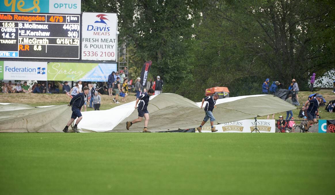 WET: The covers come on at Eastern
Oval on Sunday. Pictures: Luka Kauzlaric