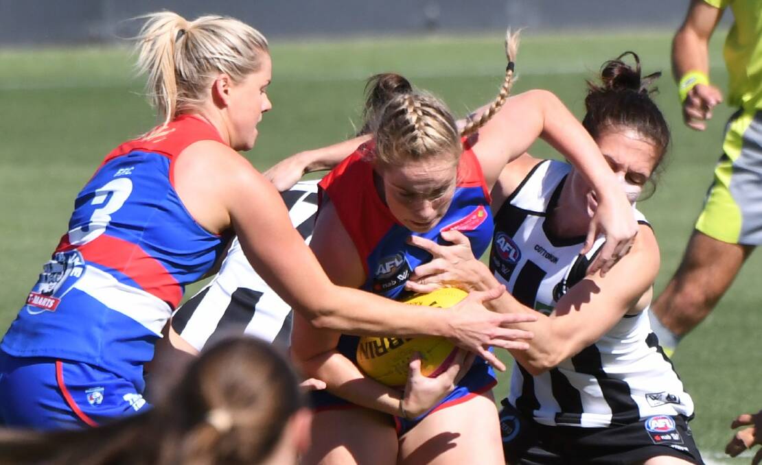 STRONG TACKLE: Western Bulldogs' Aisling McCarthy tries to breakthrough a tackle on Saturday. The Bulldogs prevailing by seven points.