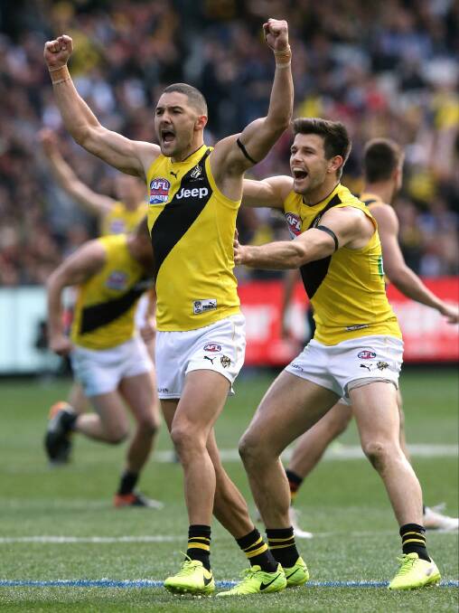 CLUTCH: Richmond's Shaun Grigg is joined by captain Trent Cotchin after Grigg slotted a crucial third quarter goal for the Tigers in Saturday's AFL grand final. Picture: Wayne Ludbey.