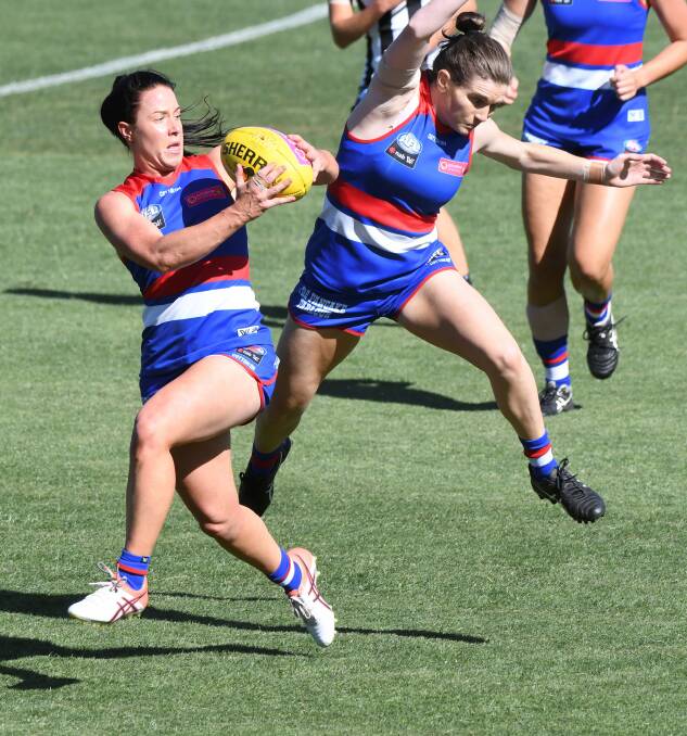 LOOK OUT: Western Bulldogs player Brooke Lochland almost has the ball spoiled by a teammate during Saturday's AFLW practice match against Collingwood. Pictures: Lachlan Bence