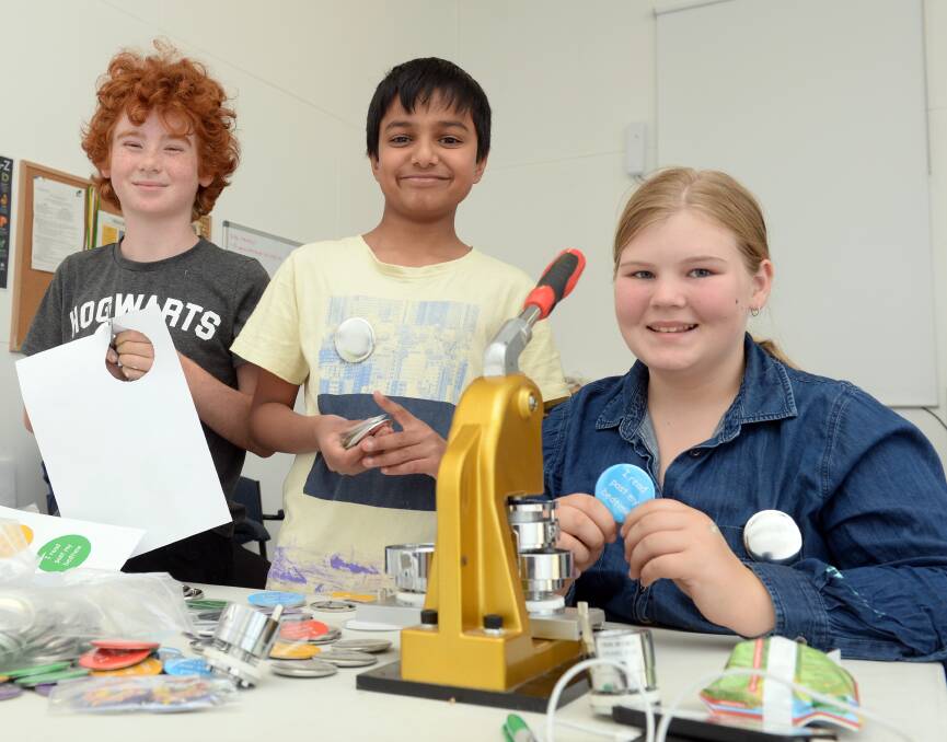 YOUNG ENTREPRENEURS: Clunes youngsters James de Kort, 10, Purv Patel, 10,  and Hannah Farren, 12, make badges to include in the showbags. Photo: Kate Healy