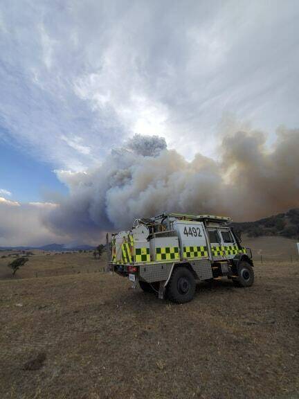 An emergency vehicle in front of massive smoke rising from wildfires burning in East Gippsland. Picture: Department of Environment, Land, Water and Planning