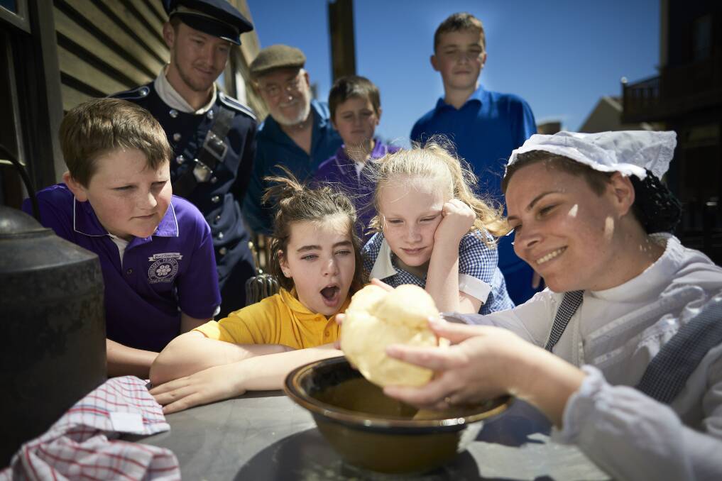 FUN: Sebastopol Primary School pupils make damper with Erin Santamaria and other Sovereign Hill big buddies in a visit to the open-air museum after months of swapping letters. Picture: Luka Kauzlaric
