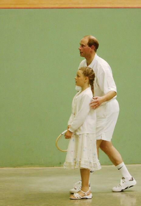A LOVE OF THE GAME: Prince Edward Earl of Wessex is pictured in 2002 giving a lesson to a girl at the Sydney Real Tennis Club. He will be in Ballarat during April.