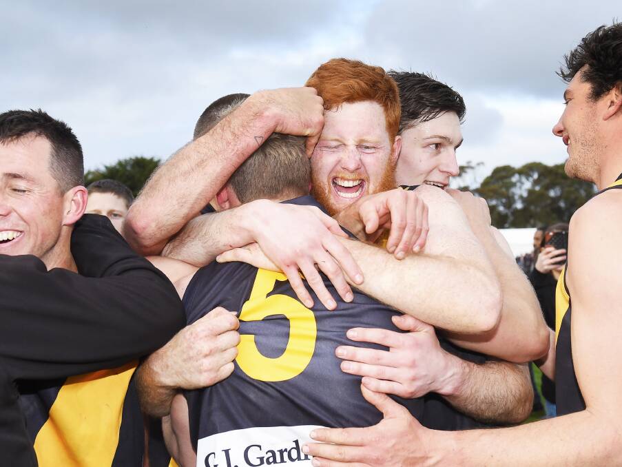 WILD SCENES: Couch embraces Springbank teammate Dan Curran on the ground following the final siren on Saturday.