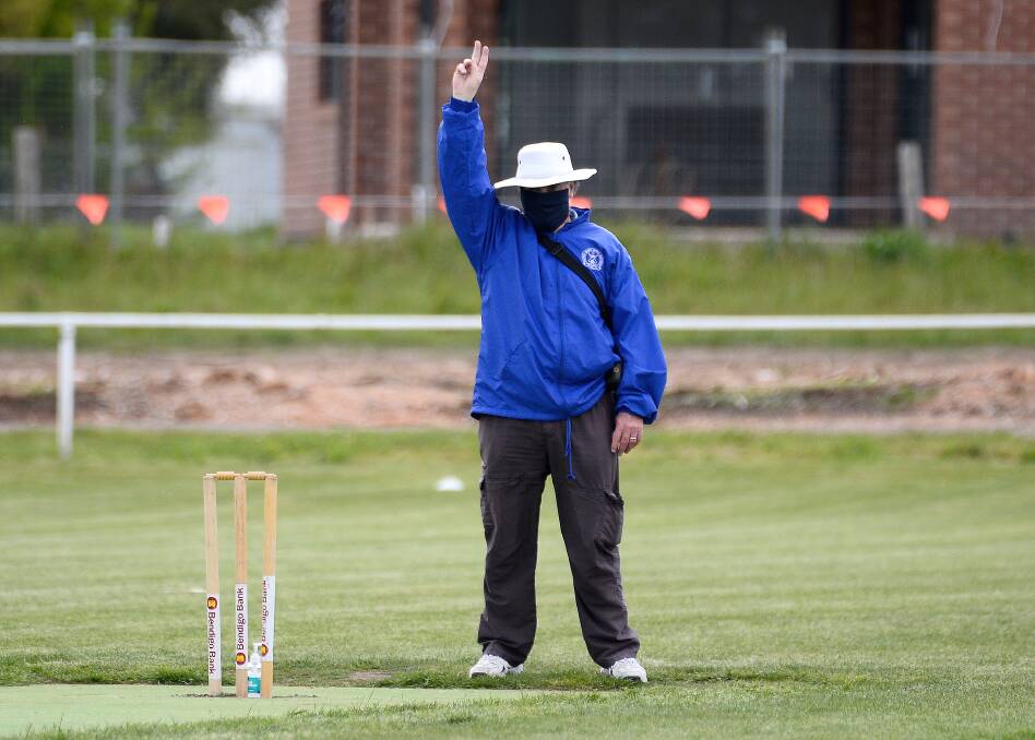 TAKE THEM OFF: An umpire wears a mask during a pre-season practice game back in October. Umpires now don't have to wear masks during play.