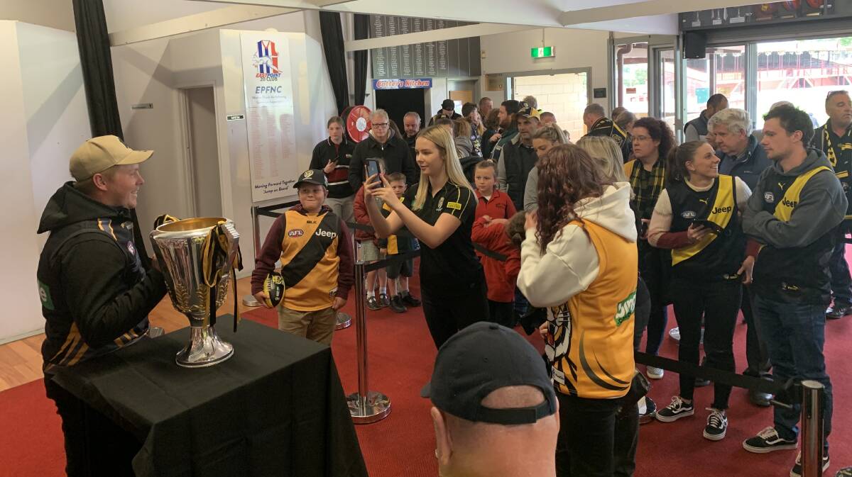 YELLOW AND BLACK: Richmond fans wait to get up close to the 2019 premiership cup at the Eastern Oval on Monday.