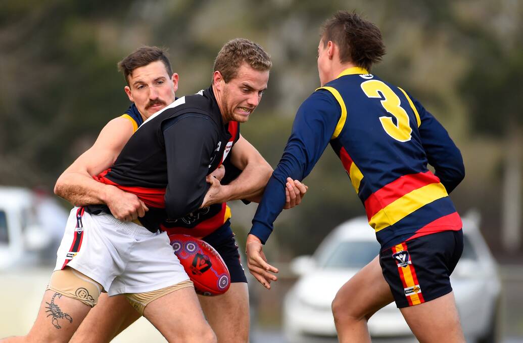 TACKLE: Lachlan Baker of Buninyong battles to get clear of Beaufort's Alexander Coleman during Saturday's senior clash. Picture: Adam Trafford.