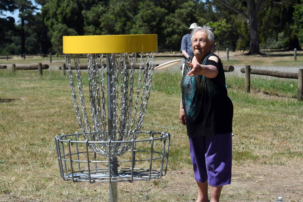 FUN: Deirdre Humphries shoots for the bucket at the new disc golf course in Victoria Park on Monday. The 18-hole public course is free to play. Picture: Kate Healy.