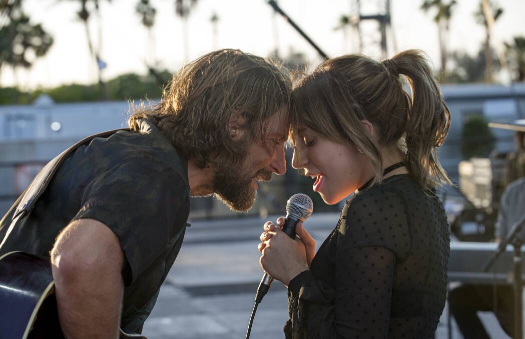This image released by Warner Bros. shows Bradley Cooper, left, and Lady Gaga in a scene from the latest reboot of the film, "A Star is Born." 