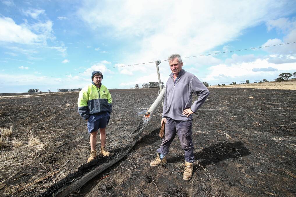 Damage: Jack Kenna Junior and Bernie Harris with the smouldering remains of the pole that snapped and sparked a fire at The Sisters on St Patrick's Day last year.