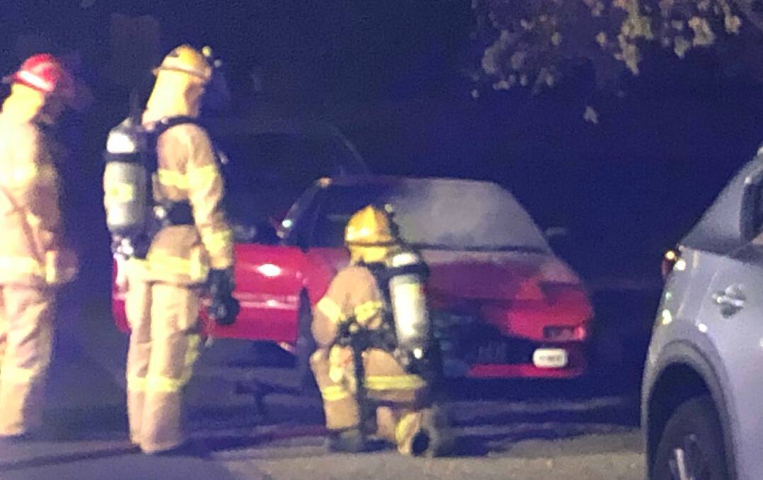 Fire crews inspect the damage of the car burnt in Soldiers Hill on Thursday night. Picture: Greg Gliddon