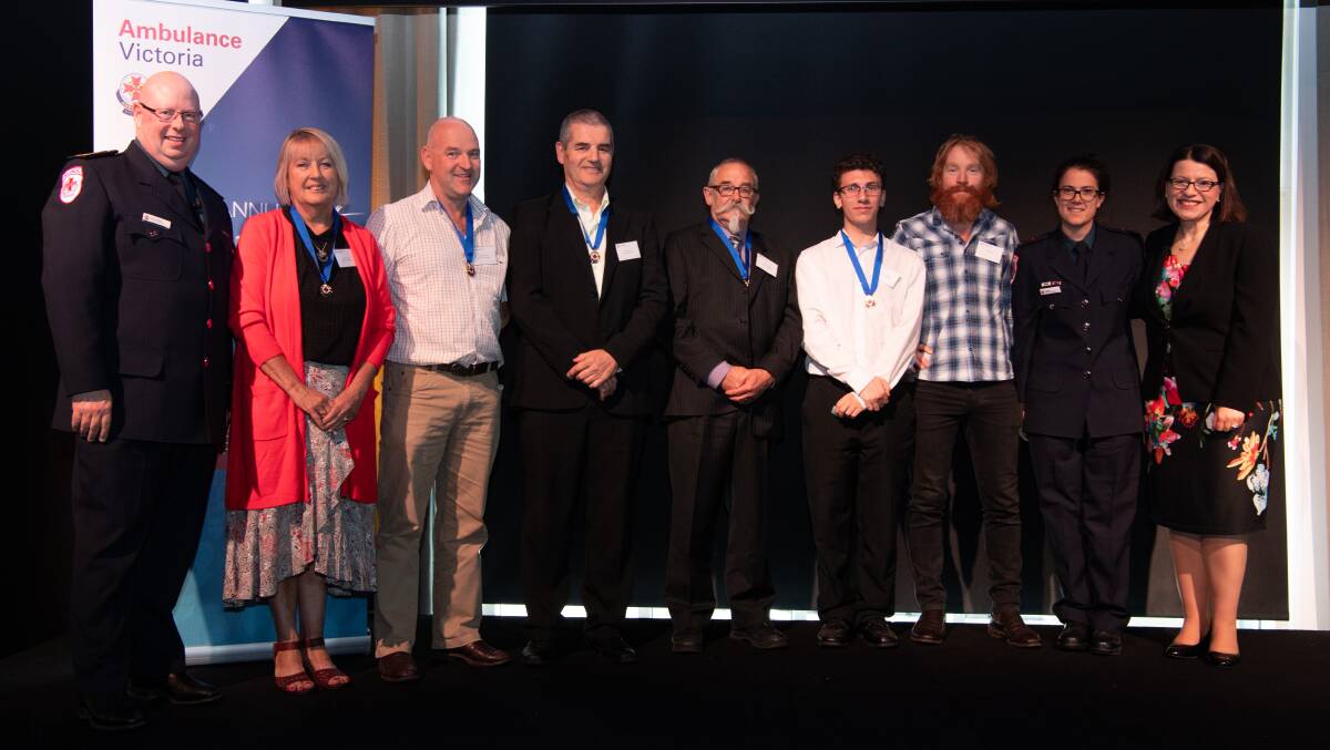 Five Ballarat residents (with medals) have been honoured for saving the life of a man who had a heart attack in June this year. Picture: Ambulance Victoria