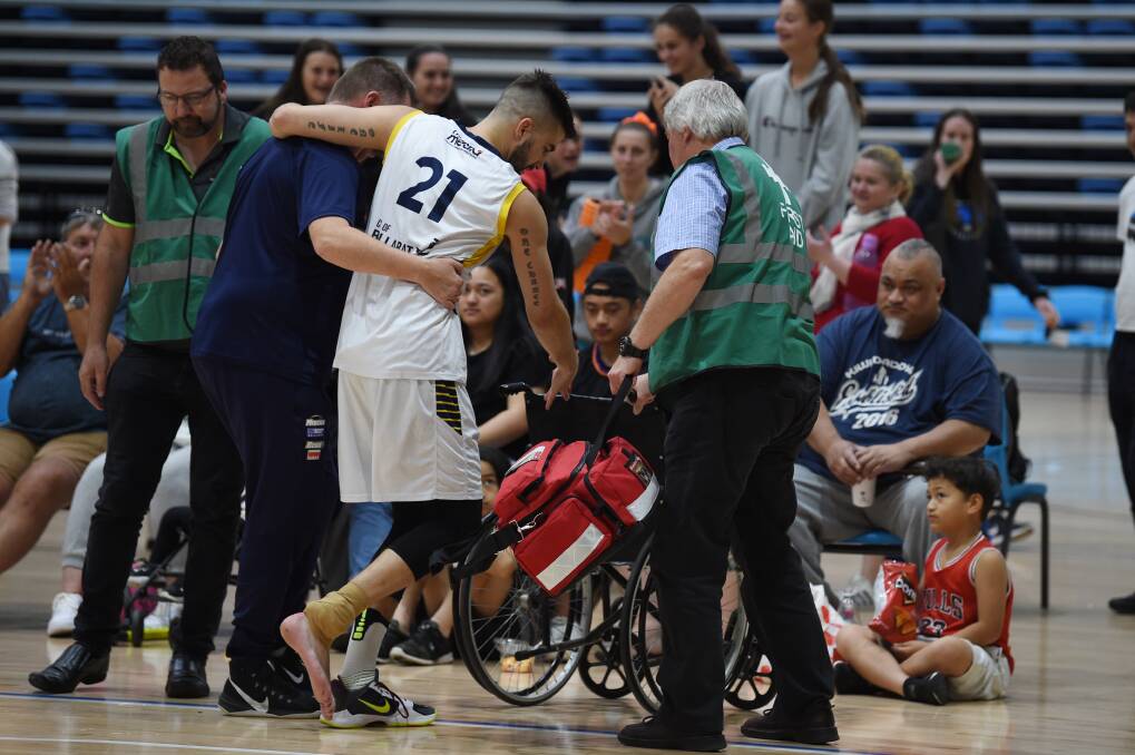 Daniel Joyce is helped off the court after hurting his achilles in the pre-season in 2020 