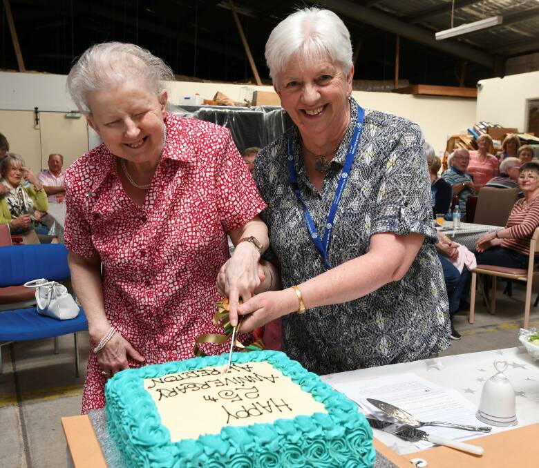 Maureen Davey and Marie Murphy cut the cake at the Vinnies Charity Shop 25th anniversary party. Picture: Lachlan Bence