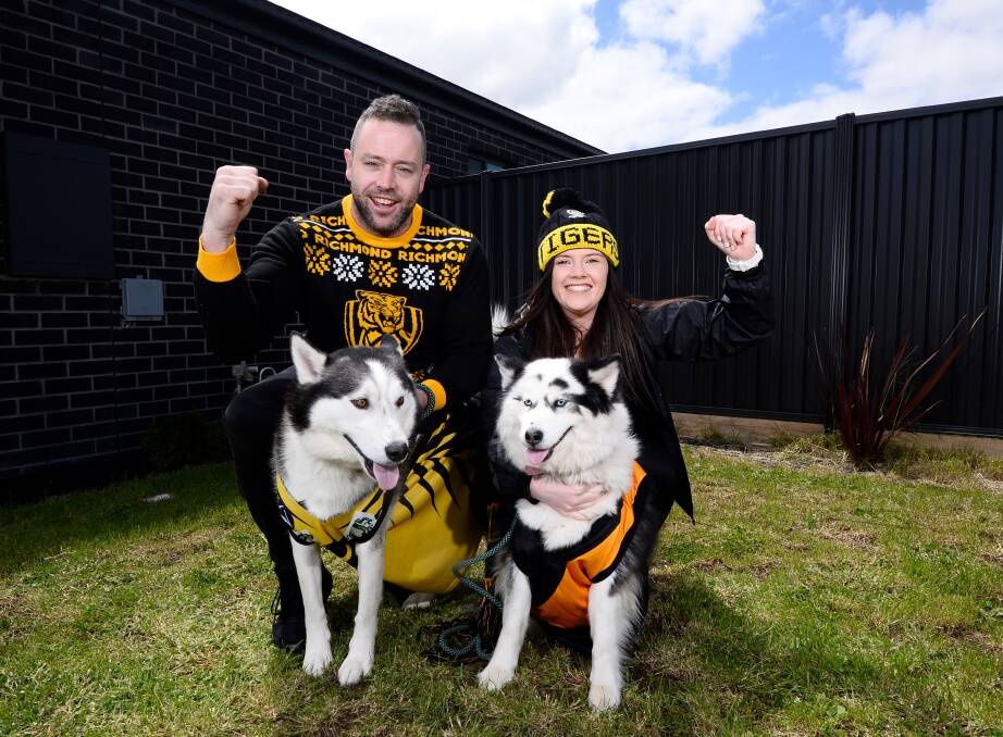 TIGER TOUGH: Daniel Knaggs and his partner Morgan Sommers with dogs Ceasar and Takani are celebrating back-to-back Richmond AFL premierships. Picture: Adam Trafford
