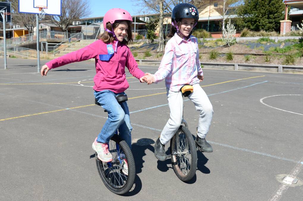 Summer and her sister Suraya ride their unicycles in tandem. Picture: Kate Healy