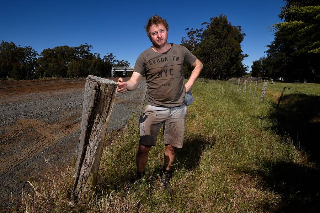 Farmer James Downey with one of split poles he says has been caused by works on the Ballarat train line. Picture: Adam Trafford