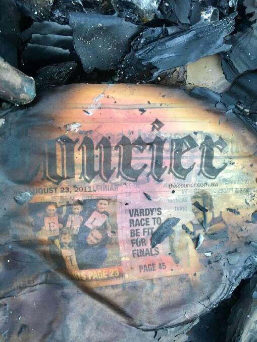 The family found an old copy of The Courier among the rubble of their home. Picture: Marcus Grigsby