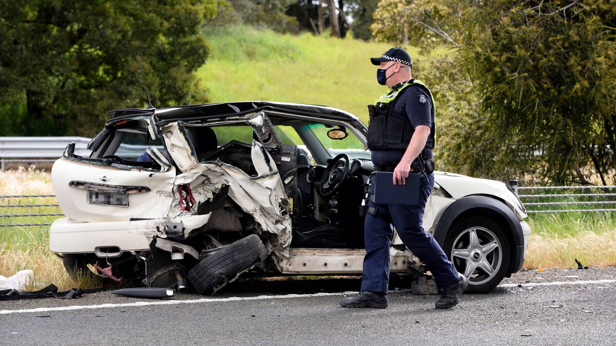 Police survey the remains of the car where a woman was killed in on the Western Freeway on Saturday. Picture: Adam Trafford