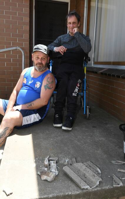 Jason Moody (in blue) had been sitting on the porch seconds before the tiles landed. Picture: Lachlan Bence