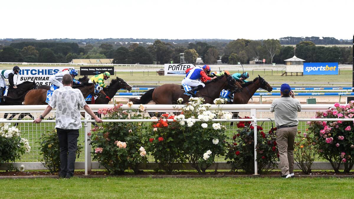 Irish Flame (jockey in green) hits the lead in the Ballarat Cup in front of a sparse crowd of around 30 owners. Picture: Adam Trafford