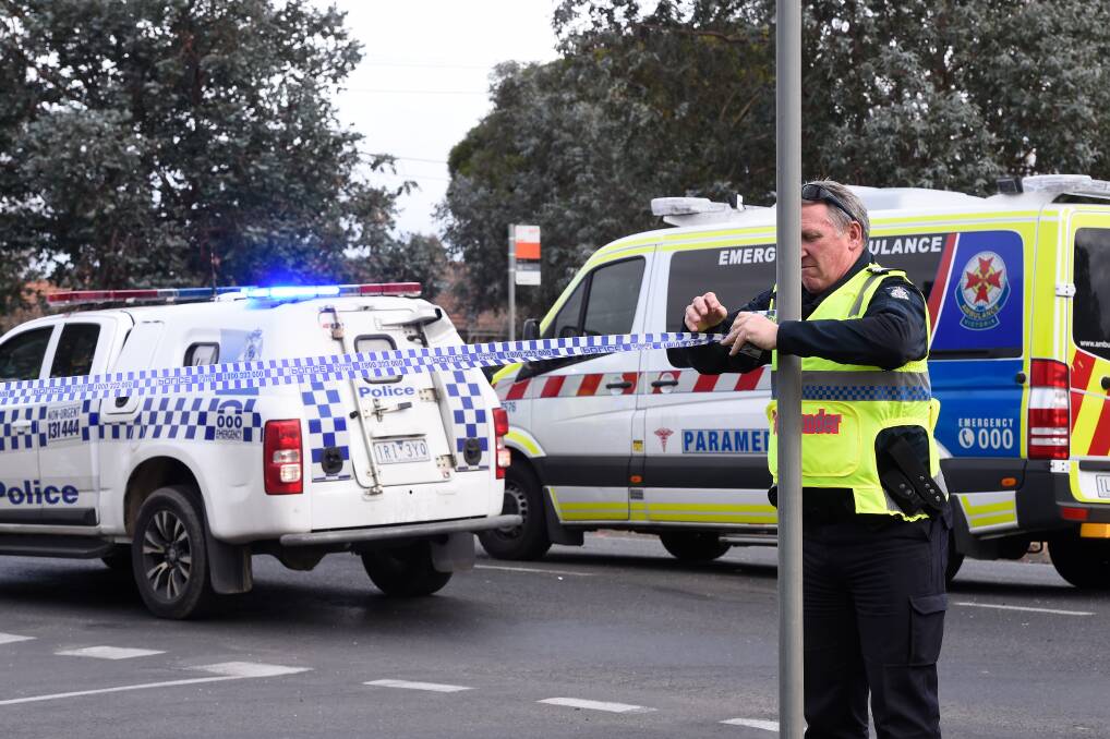 Ballarat Highway Patrol Senior Sergeant Stuart Gale puts up police tape at the scene. Photo: Adam Trafford