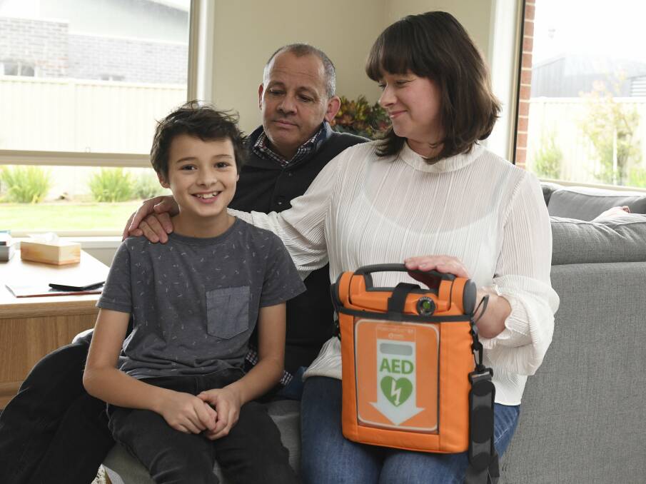 GRATEFUL: Lewis and his parents Neil and Stephanie Wilson with the defibrillator that saved his life. Photo: Lachlan Bence