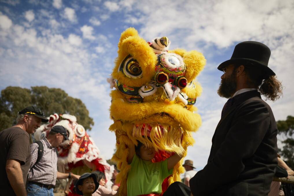 CULTURE: Andre Prince with a lion dancer performed by the Chinese Australian Cultural Society Ballarat at Sovereign Hill. Photo: Luka Kauzlaric