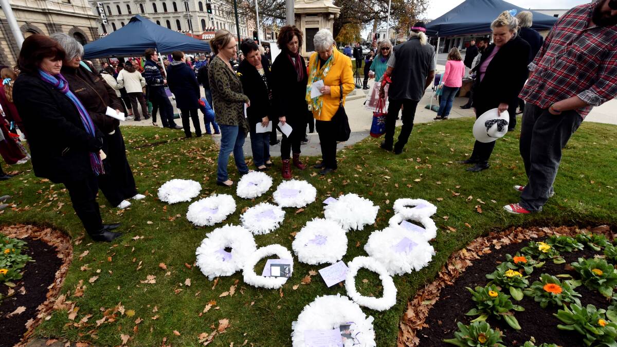 People reflecting at last year's National White Wreath Day ceremony in Victoria Square to remember people who died by suicide. 