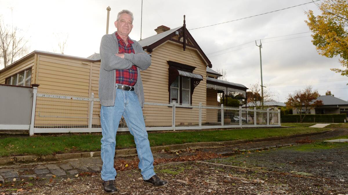 FRUSTRATED: Bruce Crawford stands where the elm tree that damaged his power line used to be. Photo: Kate Healy.