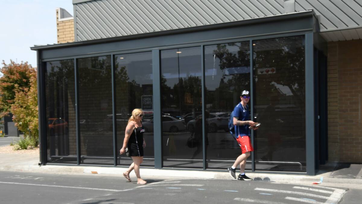CONTROVERSIAL: Pedestrians walk on the road around the airlock that has been built around the Coles supermarket entrance. Picture: Lachlan Bence. 