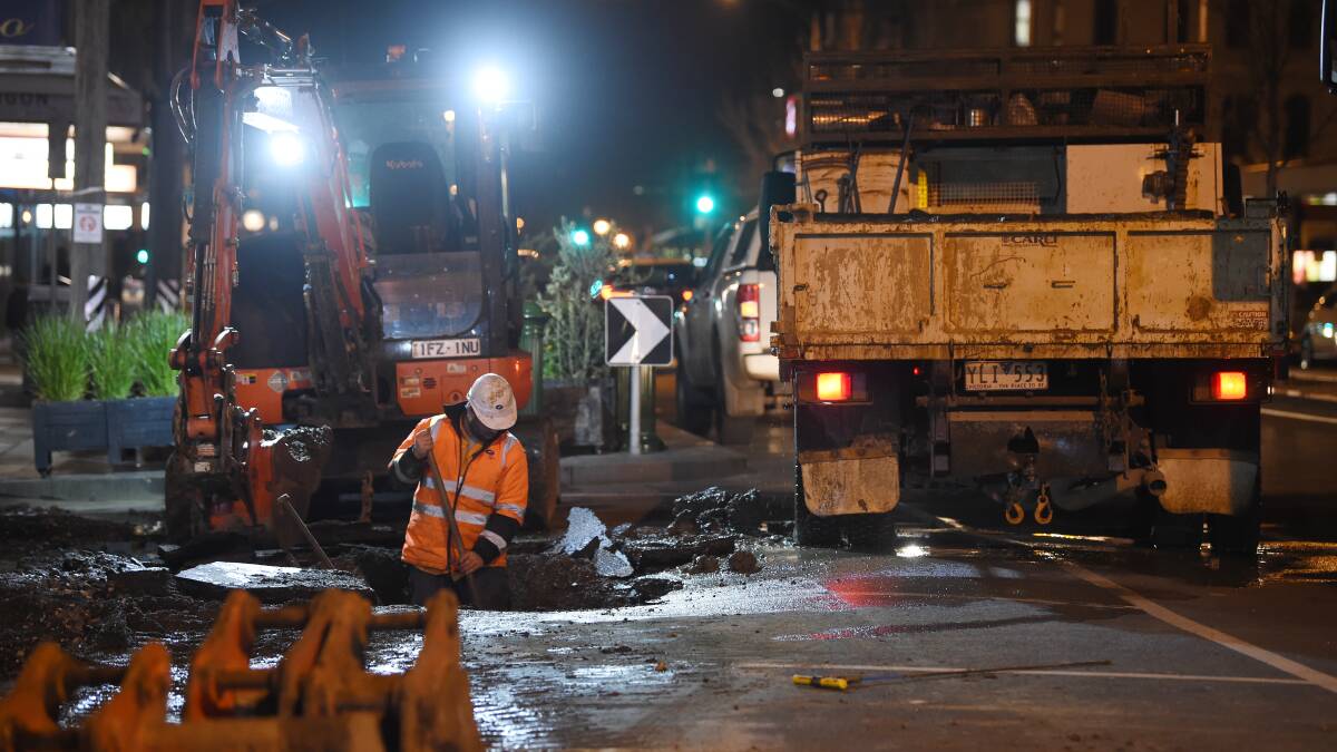 MEN AT WORK: A CHW team works to put the water back on in Armstrong Street on Friday night. Photo: Kate Healy. 