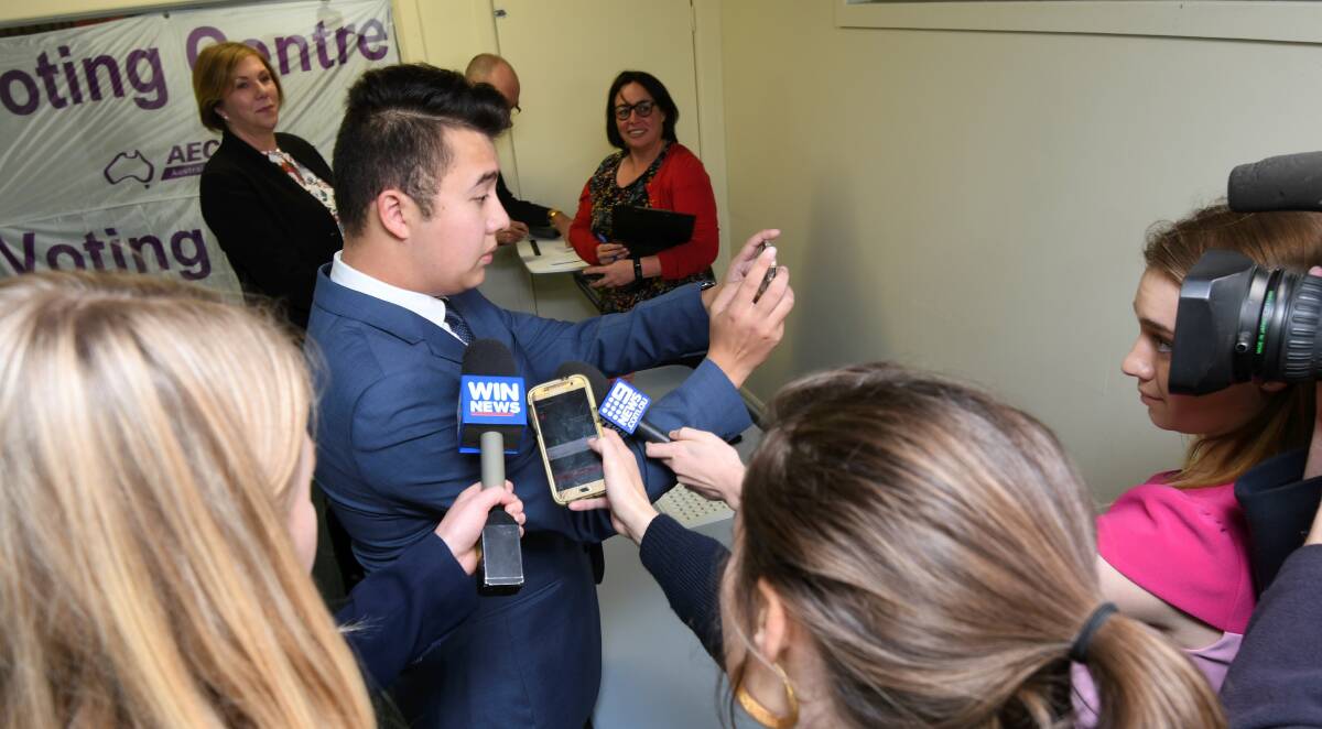 CENTRE OF ATTENTION: The Liberal Party candidate Timothy Vo is surrounded by press as Catherine King watches on. Photo: Lachlan Bence