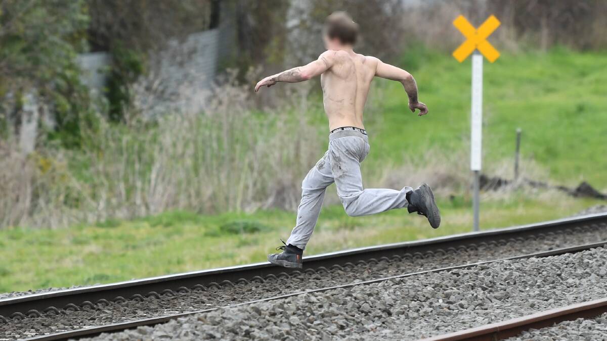 ON THE RUN: The man fled across the railway tracks then disappeared. Photo: Lachlan Bence. 