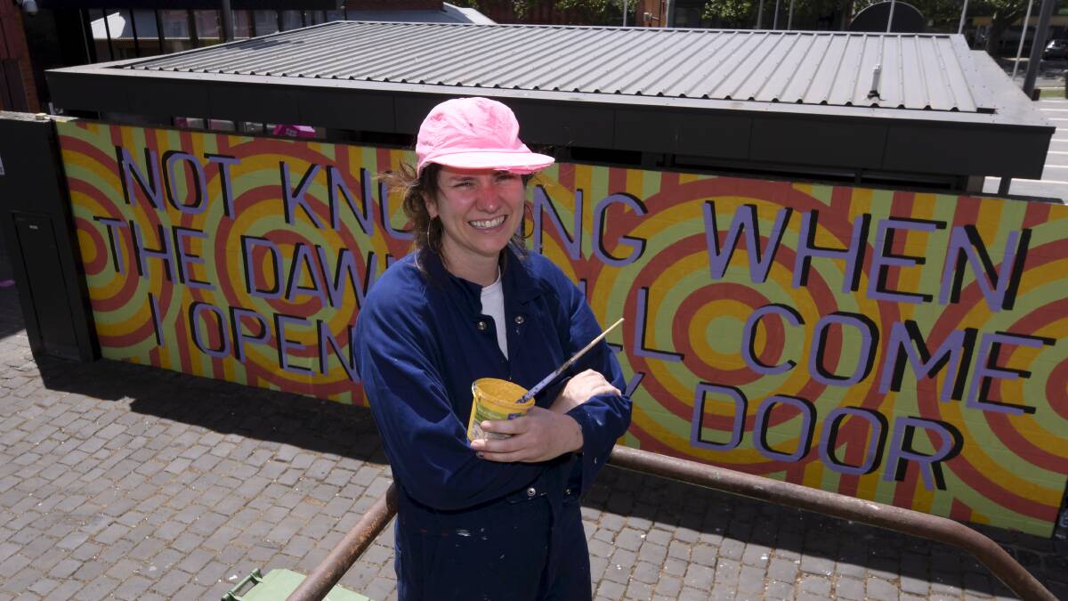 ARTIST AT WORK: Briony Galligan took five days to complete the new wall painting in Alfred Deakin Place. Photo: Lachlan Bence