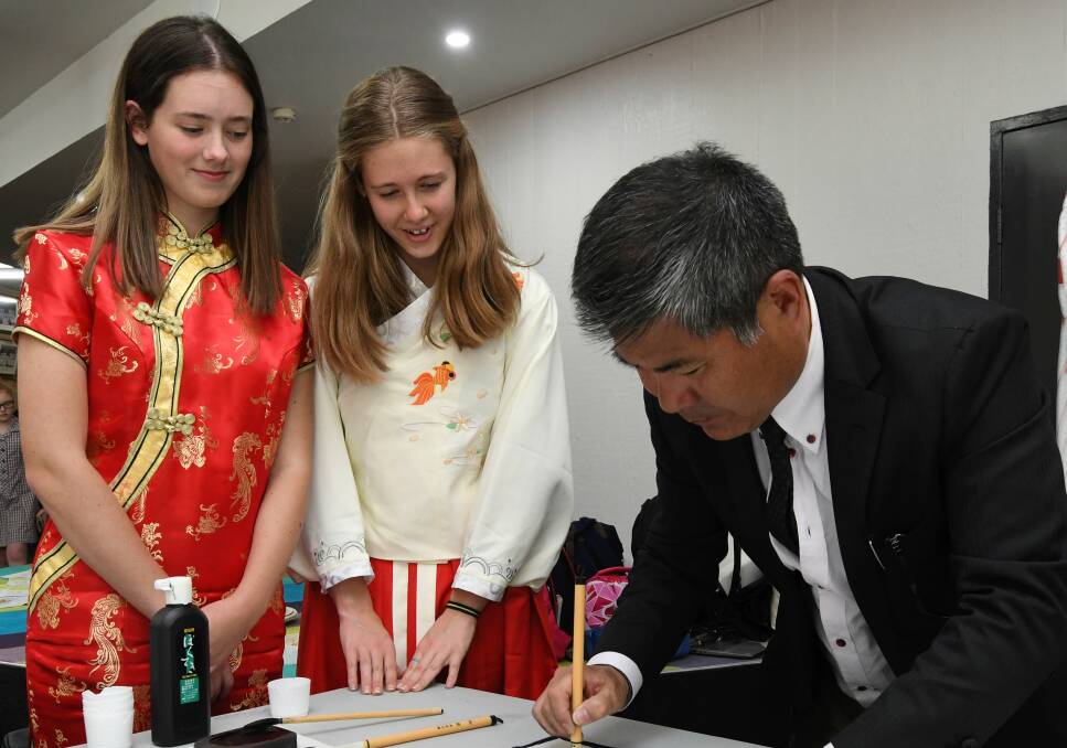 CULTURE: Mount Clear College year 12 Students Jessica Crighten, Georgia Armor observe Seikan Shibata practicing calligraphy during the school's first multicultural day. Picture: Lachlan Bence