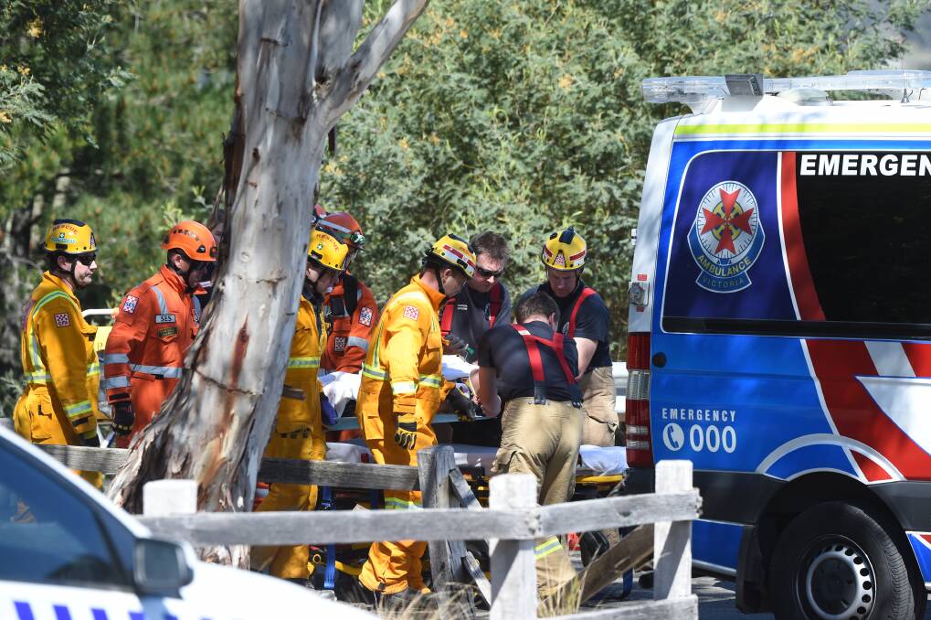 The injured youth is loaded into the ambulance after being stretchered up from the accident on the Alluvial track at Black Hill. Picture: Kate Healy