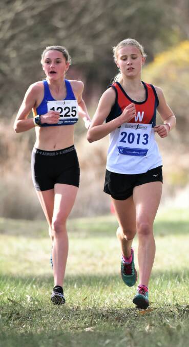 HEAD-TO-HEAD: Under-16 competitors Grace Lee Egner (Eureka) and Sophie Adamson (Wendouree) run side-by-side on the 3.2km Smythesdale circuit.