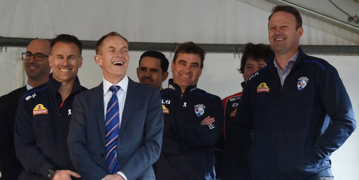 ON THE WAY UP: Chris Maple, centre with arms crossed, was the fore at Western Bulldogs' flag celebrations in his hometown Ballarat when the premiership cup came to the city.