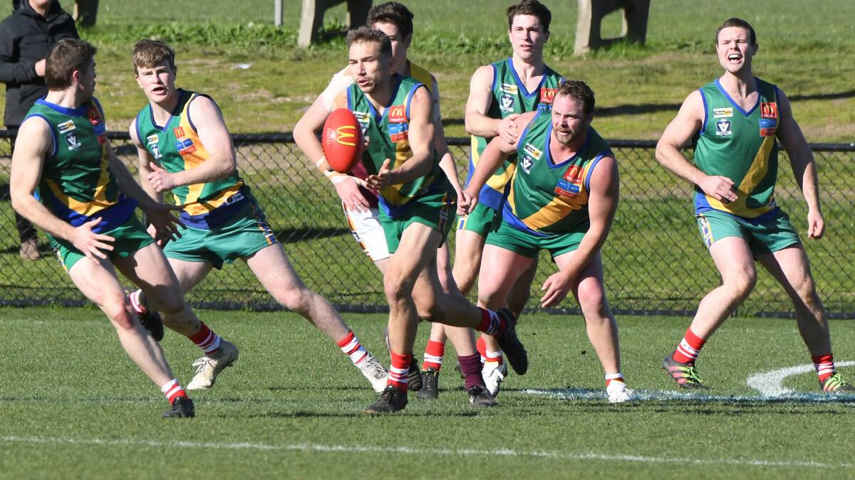 Not a photo Redan coach Jarrett Giampaolo will be pleased to see. Ben Taylor feeds a handball out to Ash Simpson as six Lakers players fill the frame - surround a sole Redan Lion. Picture: Lachlan Bence