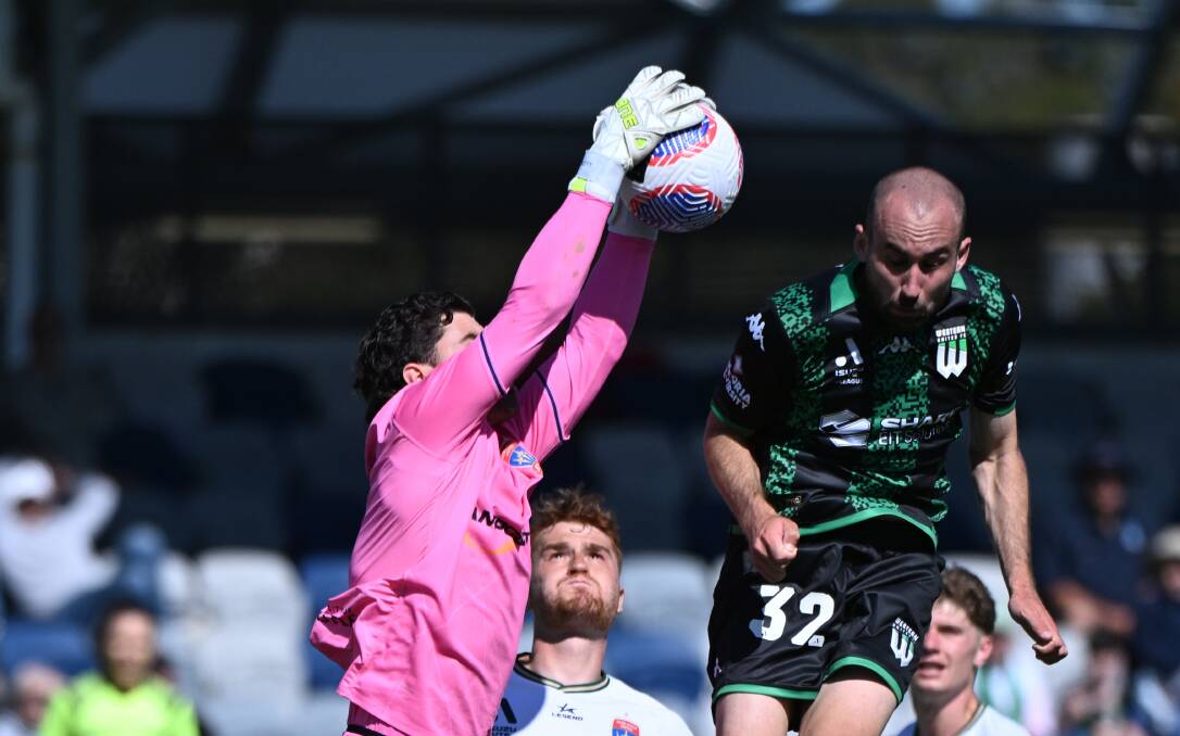 Angus Thurgate flies high in the green and black of Western United in Ballarat, but cannot beat the Newcastle Jets goalkeeper. Picture by Kate Healy 