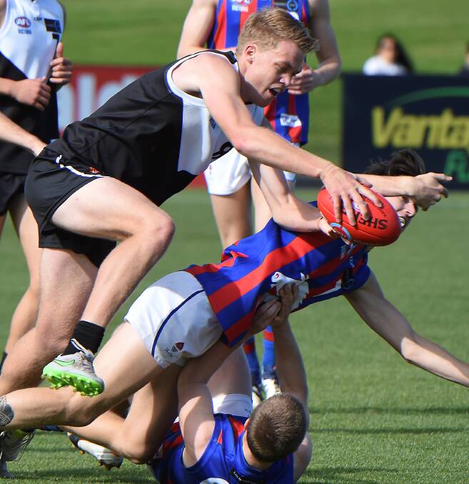 OUT OF MY WAY: Shannon Beks (North Ballarat Rebels) crashes through a couple of Oakleigh Chargers.